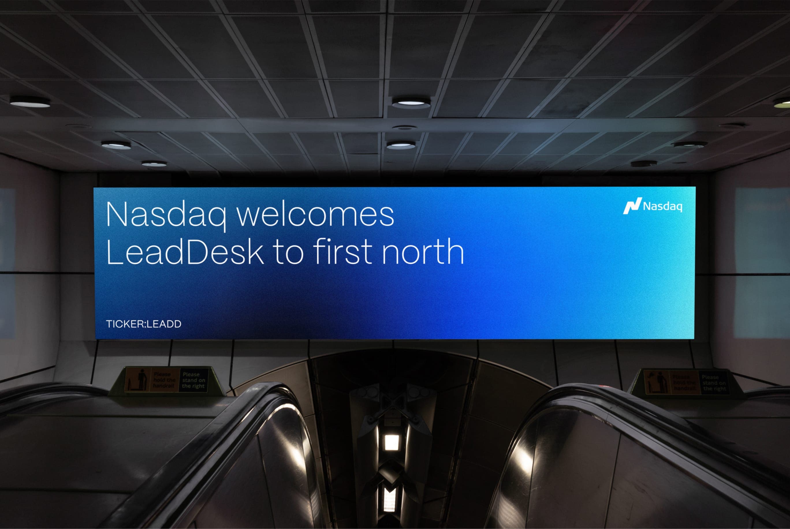 A screen above an escalator welcoming LeadDesk to Nasdaq first north