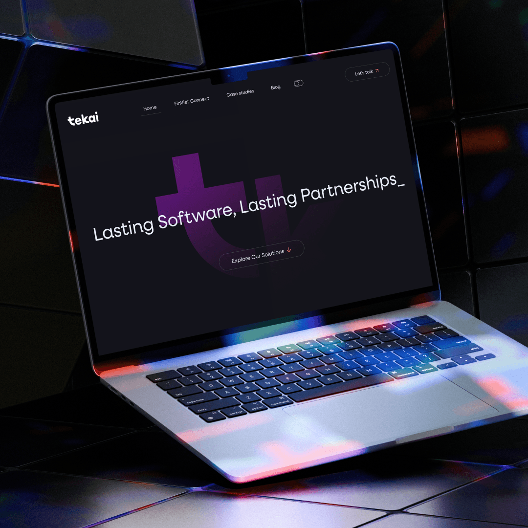 Laptop showing Tekai's dark website and purple brand symbol.