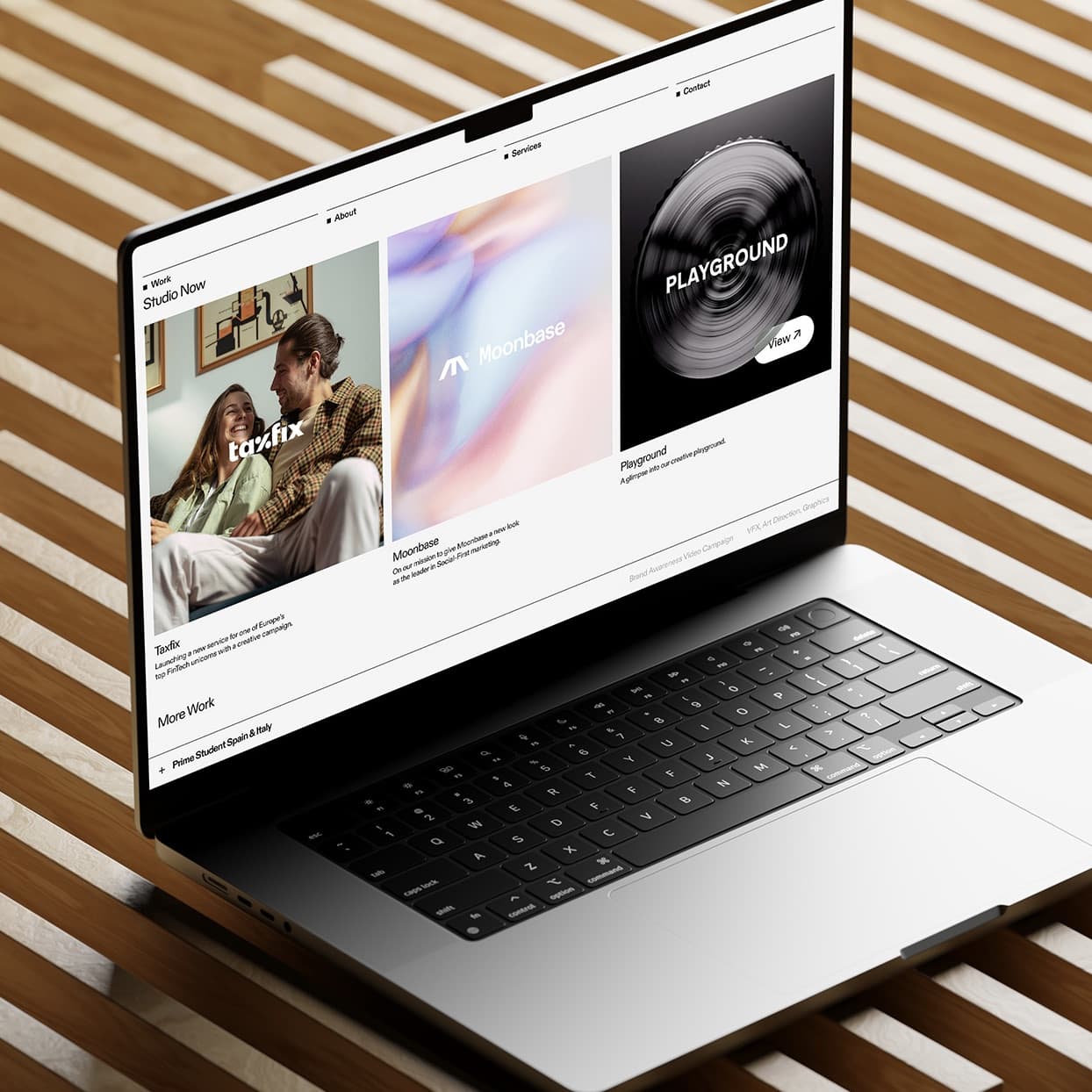 Studio Now's project portfolio displayed on a laptop resting on wooden slats.