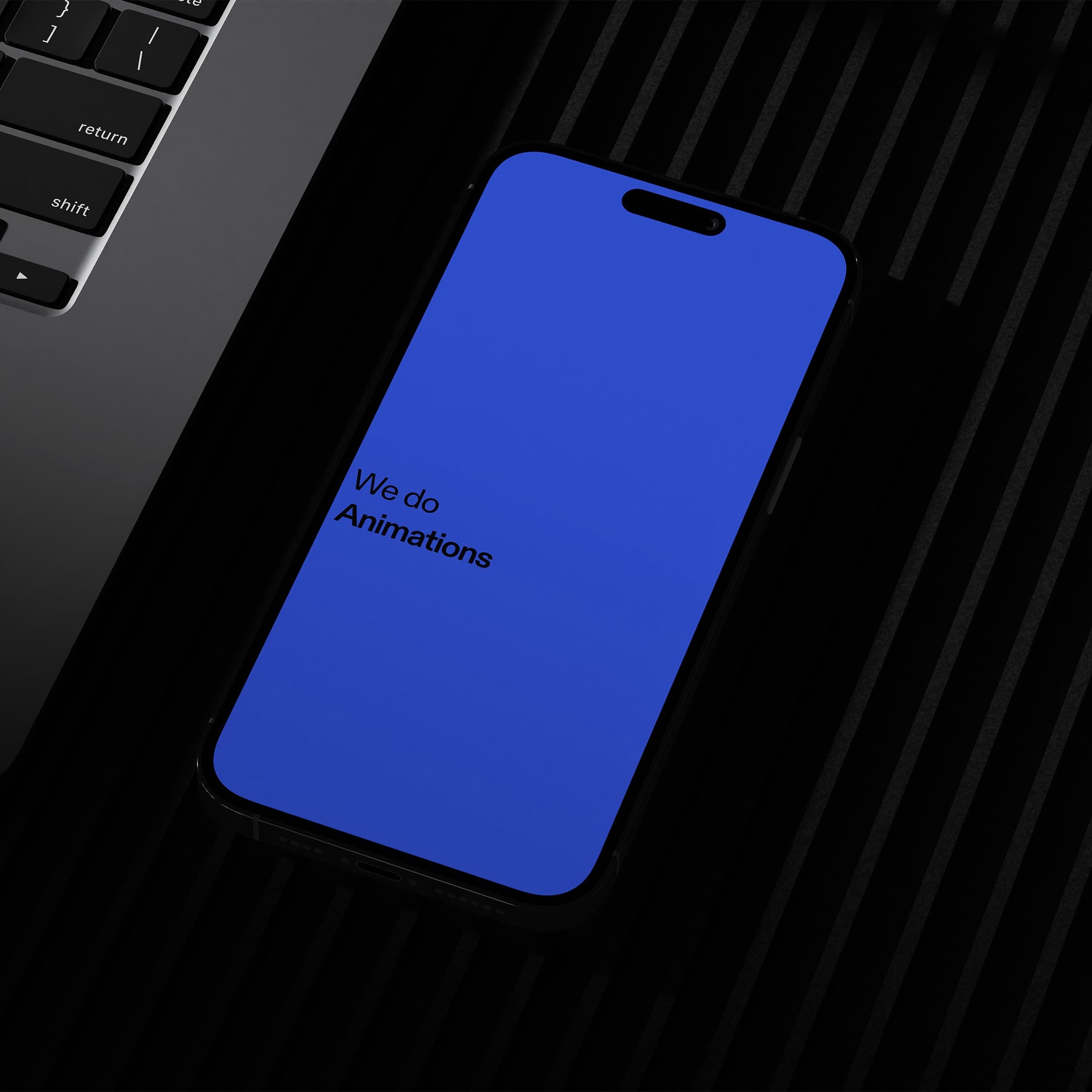Studio Now's blue mobile animation page displayed on a phone beside a laptop.